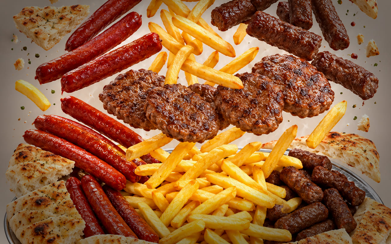 Ćevapi, Würste und Pommes frites nebeneinander angerichtet.